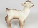 a small figurine of a goat on a white surface