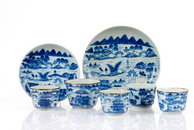 Plusieurs assiettes et tasses bleues et blanches sont posées sur une surface blanche
