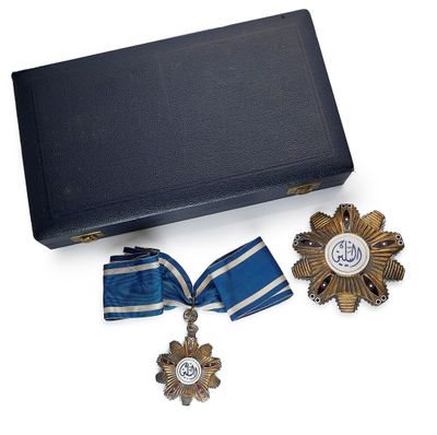 une boîte contenant une médaille, un ruban et une croix
