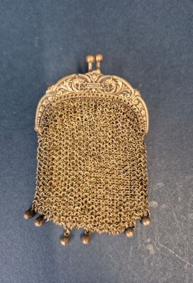 un sac à main en maille dorée à l'ancienne sur fond bleu