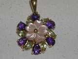 une image représentant un pendentif en forme de fleur violette et verte sur un fond blanc