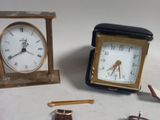three different types of clocks on a white table