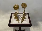 pair of antique brass candlesticks on a chess board
