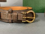 a brown belt with a gold buckle sitting on a table