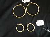 trois paires de boucles d'oreilles créoles en or sur fond noir
