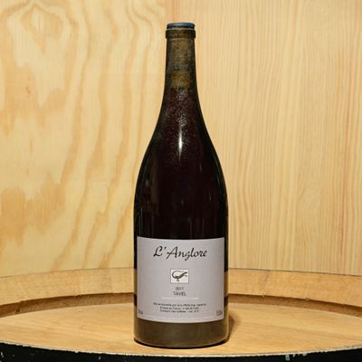 a bottle of wine sitting on top of a wooden barrel