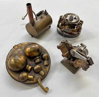 Plusieurs types d'objets métalliques sont exposés sur une surface blanche