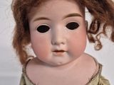 a close up of a doll with long hair on a white background