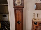 a grandfather clock that is in the corner of a room