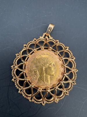 a close up of a gold medallion with a woman on it