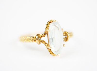 a close up of a gold ring with a white stone