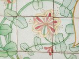 a picture of a tile with a bird and flowers on it