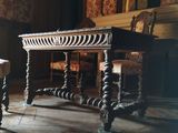 une table et deux chaises dans une pièce avec une cheminée en arrière-plan