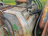 une machine posée par terre à côté d'une clôture