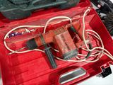 a red tool box with a drill and other tools in it