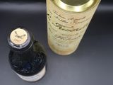 une bouteille de vin à côté d'une canette sur une table