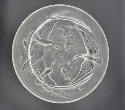 une plaque de verre ornée d'un motif représentant un oiseau et un poisson