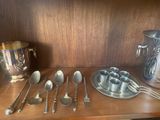 a lot of silver spoons and spoons on a shelf