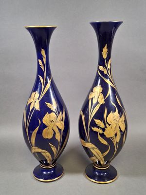 une paire de vases bleus et dorés ornés de fleurs sur fond gris