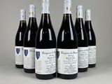six bouteilles de vin sont alignées sur une table