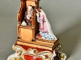 a figurine of a man and a woman sitting on a bench
