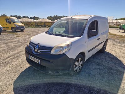 La camionnette blanche est garée sur un parking, avec d'autres véhicules en arrière-plan.