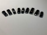 five black toy cars lined up on a white surface
