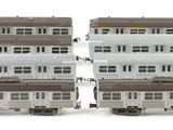 two white and brown train cars sitting next to each other on a white surface