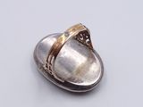 silver and gold plated broochle with a ring on top of it