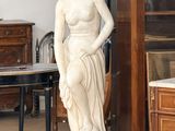 une statue représentant une femme debout dans une pièce