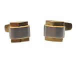 deux paires de boutons de manchette en or et en bois sur fond blanc