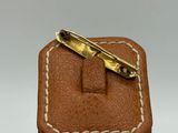 brown leather box with a gold tie bar on top of it