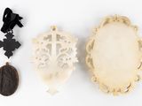 two pieces of carved ivory with a cross and a cross pendant