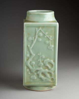 a green vase with a design on it on a table