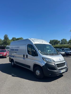 une camionnette blanche garée dans un parking à côté d'autres voitures