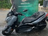 a black motorcycle parked in front of a sign that says nautius