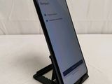 a close up of a cell phone on a stand on a bed