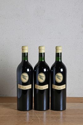 three bottles of wine sitting on top of a wooden table