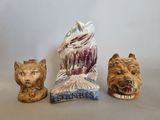 trois figurines représentant des chiens et un chat, posées sur une table