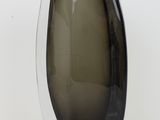 un vase noir et blanc posé sur une surface blanche