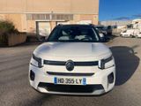 the front of a white car parked in a parking lot