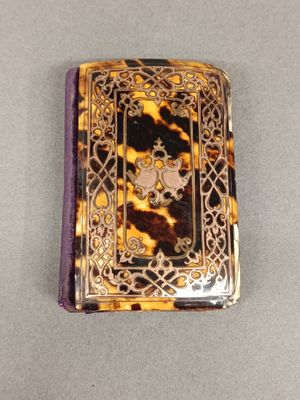 livre argenté et écaille de tortue, orné d'une croix sur la couverture