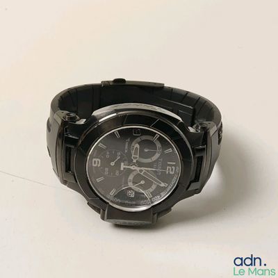 une montre posée sur une surface blanche