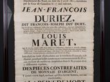une affiche en noir et blanc, encadrée de noir, accrochée au mur