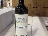une bouteille de vin posée sur une table devant des boîtes