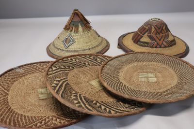 several straw hats are stacked on top of each other on a table