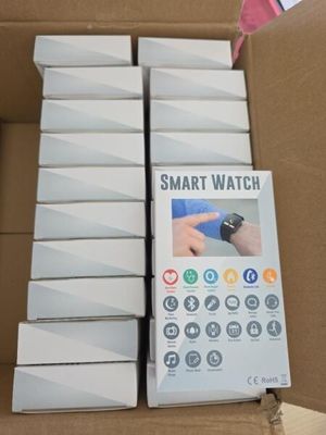 Des boîtes contenant des montres connectées sont empilées les unes sur les autres dans un carton.