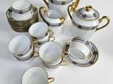 many cups and saucers sitting on a white table