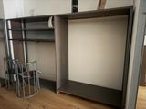 a closet in the corner of a room with a chair next to it