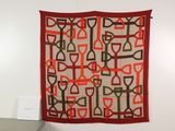 a wall hanging with a red and brown design on it